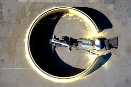 MIT researchers have designed a system that can 3-D print the basic structure of an entire building. The system consists of a tracked vehicle that carries a large industrial robotic arm, which has a smaller, precision-motion robotic arm at its end. 
