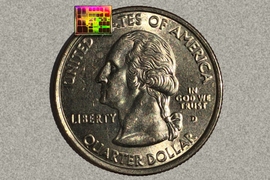 A new computer chip, smaller than a U.S. dime and shown here with a quarter for scale, helps miniature drones navigate in flight.