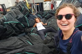 Two people on a large boat with huge black nets
