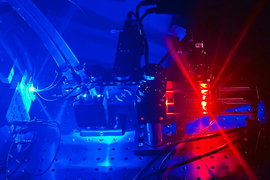 Blue and red light show a microscope and lab setup.