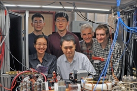 Group photo in the lab in front of a table of devices.