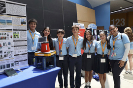Six students and a teacher pose at EurekaFest.