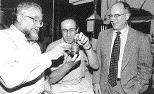 MIT engineer Alexander Rabinovich holds a device he developed with Leslie Bromberg (left), Daniel Cohn (right) and colleagues that could significantly reduce the amount of smog-producing pollutants generated by cars.