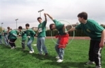 "They Might be Tools," a Johnson Games team sponsored by the Women's Independent Living Group, works together to move hula hoops down the line.