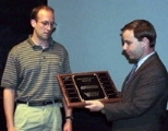 Terence Emert (left) prepares to receive the Charles "Harrison" Smith III Memorial Award from LFM student Rob Mosher, a friend of the late Mr. Smith