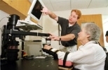 Dan Doherty, a physical therapist at Spaulding Rehabilitation Hospital, helps Frances Heimberg work with MIT-Manus during her rehabilitation therapy following a stroke.