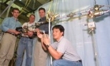 MIT researchers in the Department of Aeronautics and Astronautics stand with the instrumented truss that is key to the first hands-on experiment aboard the International Space Station. Left to right are Sophomore Cemocan Yesil, Associate Professor David Miller, Postdoctoral Fellow Gregory Mallory, and Graduate Student Jeremy Yung.
