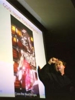 Rodney A. Brooks, director of the Artificial Intelligence Lab (AI Lab), gave the opening talk at the Humanoids 2000 Conference. On the screen is Cog, a humanoid robot developed at the AI Lab.
