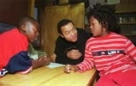 George Samuels (center) helps 11-year-olds Corey Godfrey (left) and Francis Reddick plan how to finance a holiday event they want to hold at the Area IV Youth Center. Mr. Samuels is one of several DUSP graduate students involved in the Young People in Planning project at the center.