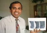 Professor Subra Suresh holds images of the bubble experiment that has informed his study of the movement of atoms.