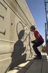 Jerry LeBlanc of Phoenix Baystate fits a stone in place over the 77 Massachusetts Ave. entrance, where the damaged facade is being repaired. For other construction photos and updates, see page 5.