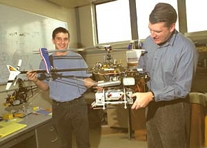Graduate student Ioannis Martinos and Professor Eric Feron of the Department of Aeronautics and Astronautics hold the robotic helicopter they helped develop.