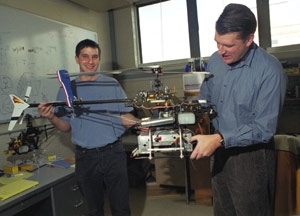 Graduate student Ioannis Martinos (left) and Professor Eric Feron hold the robotic helicopter they helped develop.