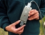 A student holds one of the sensor boxes before it was mounted on a flagpole to measure that structure's response to the wind.