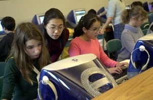 MIT faculty and students went to the Agassiz School in Cambridge to teach students there how to model systems on the computer using the StarLogo program.  Melanie Wong, a senior in political science, gives a little coaching to Morgan (far left) and Halima. Clarissa sits to their left.