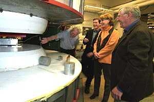 Ulrich Becker, MIT professor of physics, left, gestures as he  shows MIT's cyclotron May 7 to actors Hank Stratton, Mariette Hartley, and Len  Cariou, who comprise the cast of the play "Copenhagen" currently at  the Colonial Theater in Boston.