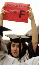 Graduating senior Melanie Pincus holds a sign protesting the World Bank .