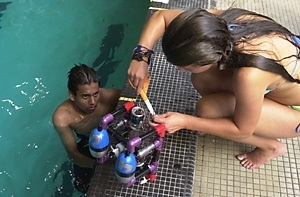 Electrical engineering sophomore Saagar Gupta waits in Alumni Pool as incoming freshman Jill Konowich puts the finishing touches on the ROV she and her partner built in the Department of Ocean Engineering's pre-orientation program.