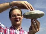 Researcher Stephen Slivan displays a model he made to explain the orientation of asteroids.