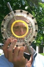 Saul Griffith looks through the lens molder of the portable device he invented  to make low-cost prescription eyeglasses for people in the developing world. Griffith  won the Collegiate Inventors Competition and was inducted into the Inventors Hall  of Fame last month.