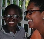 While on a trip to distribute donated eyeglasses, senior Selam Daniel (right) smiles after fitting a very nearsighted Guyanese boy with his first pair of glasses.