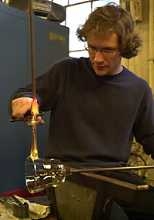 Instructor Chris Laughman, a research engineer in electrical engineering and computer science, cuts molten glass to make a handle.