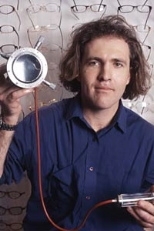 Saul Griffith, 2004 winner of the $30,000 Lemelson-MIT Student Prize, holds part of his lens molding device that can produce any prescription lens quickly and inexpensively. Griffith describes the device as a "desktop printer for eyeglasses" and envisions its use in developing countries where billions of people cannot access nor afford prescription lenses.