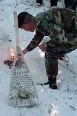 An Army staff sergeant demonstrates how to start a fire using the magnesium from a snowshoe.