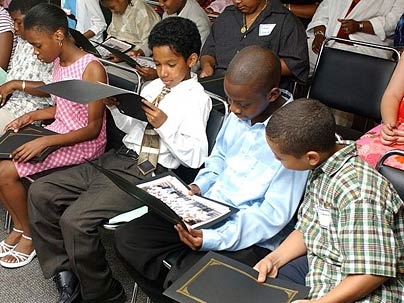 From left: Tiona Edwards, Krystian Eaglehorse, Dwayne James and Troy Jimenez look over their certificates and group photos at the final program of the MIT STEM summer program.