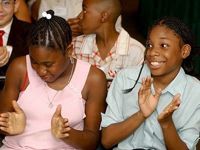 Kamisha Green, left, and Jennifer Jones clap in delight during the final program for STEM students at MIT.