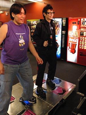 MIT junior Noe Kamelamela, left, and Streb boogie on a dance machine in MIT's Stratton Student Center.