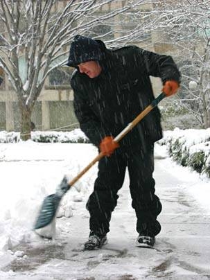 Custodian Brian Caterino puts his back into his job during a recent snowstorm. All the grounds staff pitch in to make sure that pathways are cleared for travelers on campus.