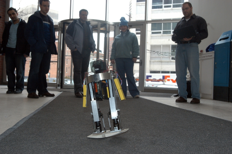 MIT's 'robotoddler'  walks down a carpet as an appreciative audience looks on.