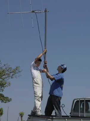 MIT senior Edgar Terrero helps Pilo of Centro Tecnico in Honduras hold up a directional antenna for a test of the radio component of a flood early warning system.