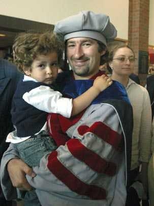 Newly hooded Artur Arsenio holds a shy but happy son, Hugo, 3, after the hooding ceremony on Thursday, June 2. Arsenio received the Ph.D. in electrical engineering and computer science.