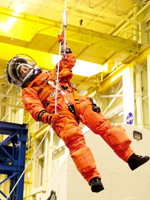 Astronaut and MIT alumna Wendy B. Lawrence, currently aboard the Space Shuttle Discovery, uses a climbing apparatus to lower herself from a simulated trouble-plagued shuttle in an emergency egress training session at Johnson Space Center in September 2004.