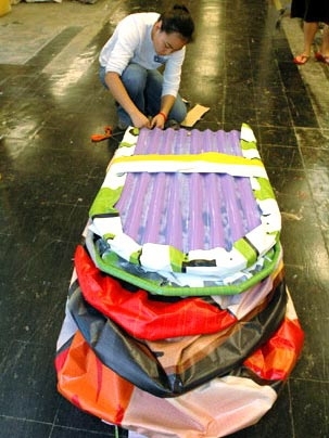 Andrea Urmanita, a senior in architecture, folds up the portable homeless shelter that her team made for the class.