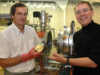 MIT research scientists Steve Kissel, left, and Mark Bautz hold up a copy of the core element used in their X-ray camera.