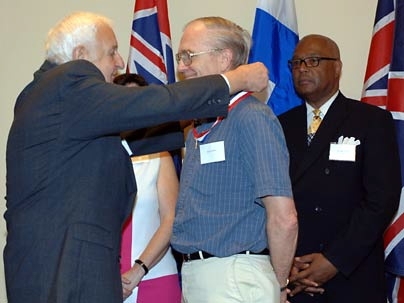Marshall Sloane, Chairman of Century Bank, left, bestows the Distinguished Eagle Scout Award on Professor Kim Vandiver, Edgerton Center founder and former Eagle Scout, as Cambridge Mayor Kenneth Reeves, right, looks on.