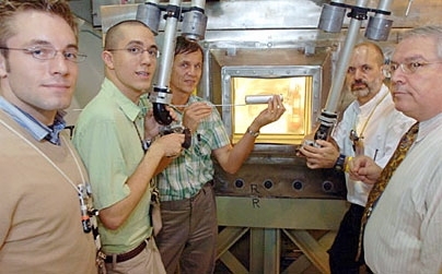 MIT researchers working on the next generation of nuclear technology test-fit a prototype fuel capsule using the manipulators of a hot box at MIT's Research Reactor.