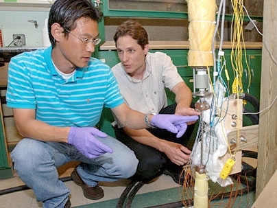 Graduate student Sung Joong Kim, left, and research scientist Thomas J. McKrell inspect the test section of the nanofluid critical heat flux facility. Lab work on nanofluids holds promise for improving nuclear power generation.