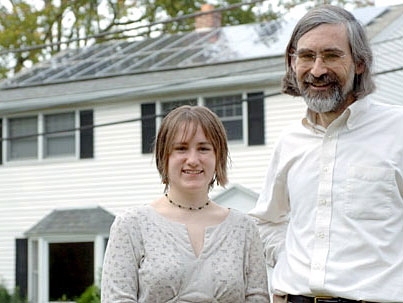 Professor David Vogan poses with his daughter, Ali, in front of their home in Arlington. The solar panels on their roof were installed thanks to support from MIT.