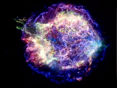 A supernova remnant acts like a relativistic pinball machine by accelerating electrons to enormous energies. The blue, wispy arcs in this image of Cassiopeia A, the youngest supernova remnant in the Milky Way, show where the acceleration is taking place in an expanding shock wave generated by the explosion. The red and green regions show material from the destroyed star that has been heated to mil...