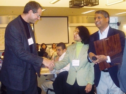 Paul Edelman '78 receives the first Desh and Jaishree Deshpande UPOP Service Award from the Deshpandes.
