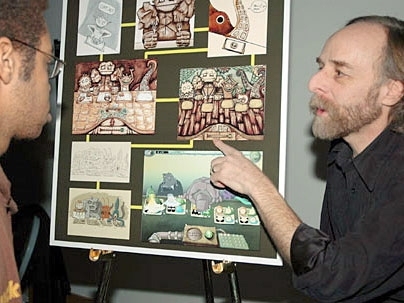 Scot Osterweil, creative director of the CMS Education Arcade, shows freshman Paul Medlock-Walton a game designed to teach math and literacy to middle school students.