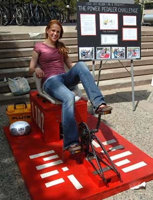 Civil and environmental engineering sophomore Liz Labuz powers the radio to her right by pedaling her team's "The Pedaler Challenge", a pedal machine that powers a radio. As a member of the CEE sophomore design course, she and her fellow classmates were required to design and built an energy-producing machine.