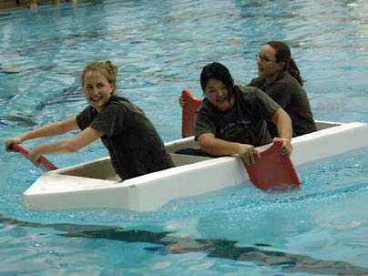 Management senior Rebecca Oman, biology senior Chensi Ouyang and mechanical engineering senior Ellann Cohen together pilot the vessel Ship Happens. The team won the Head of the Zesiger cardboard boat regatta held Oct. 19.