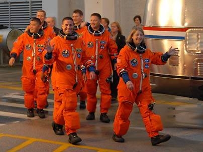 MIT alumnus Pamela Melroy, far right, led her crew to the van that took them to the space shuttle Discovery. Melroy is the first MIT alumna to command a space shuttle mission. Discovery will deliver fellow MIT alum Daniel Tani, far left, to the International Space Station where he will serve as a flight engineer.