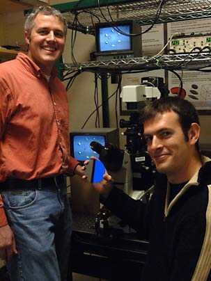 Mechanical and biological engineering professor Matthew Lang, left, and graduate student David Appleyard in the lab with equipment that shows how optical tweezers can be used to actively assemble tiny objects and cells on the surface of silicon wafers.