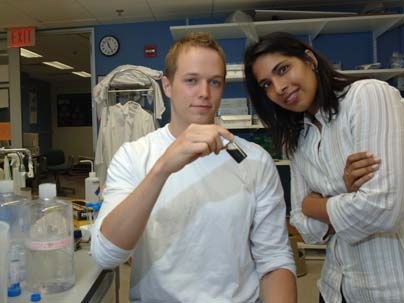 HST graduate student Geoffrey von Maltzahn and Professor Sangeeta Bhatia examine a medium in which are suspended iron oxide particles. Bhatia is leading a team using electric fields to remotely release drugs from nanoparticles inside the body.